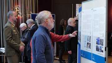 Ein Besucher liest ein Ausstellungsplakat